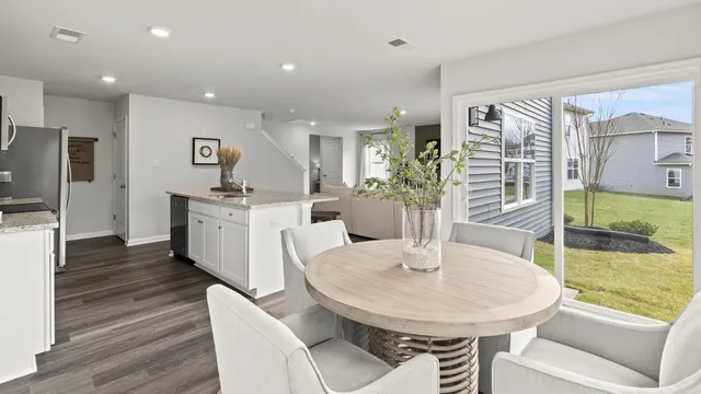 a kitchen with stainless steel appliances a dining table and chairs