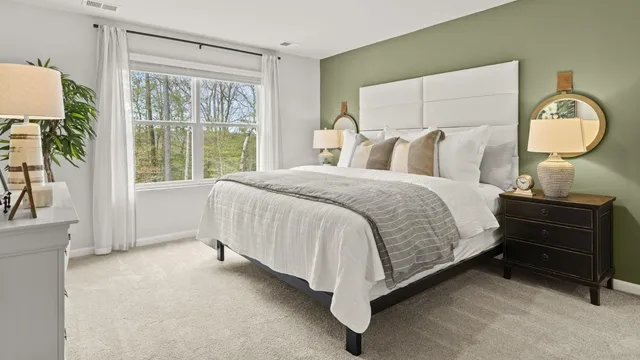 a bed sitting in a bedroom next to a window