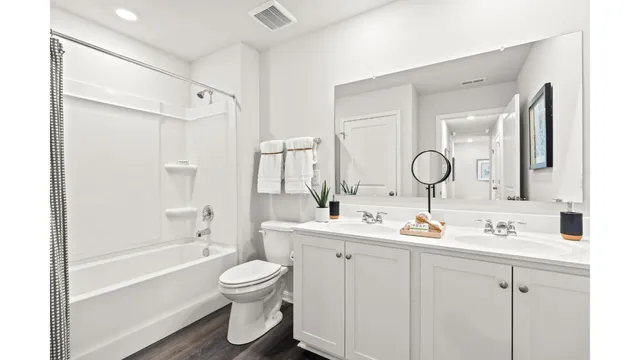 a bathroom with a double vanity sink double mirror bathtub and toilet