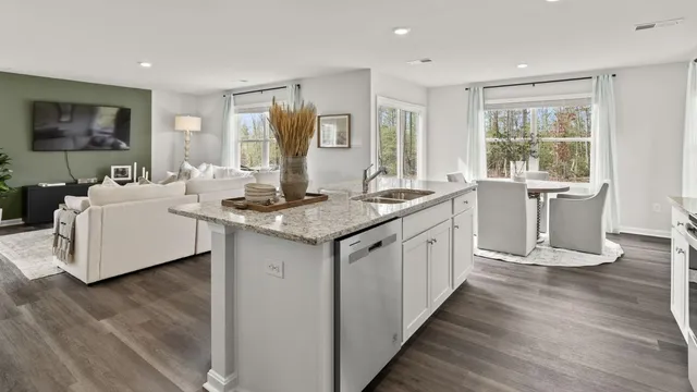 a kitchen that has a sink a stove and wooden floor
