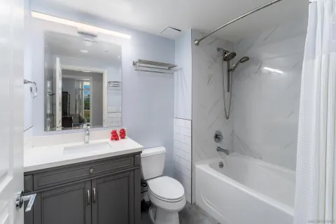 a bathroom with a sink toilet mirror and shower