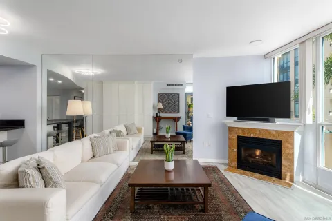 a living room with furniture a flat screen tv and a fireplace