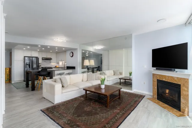 a living room with furniture a flat screen tv and a fireplace