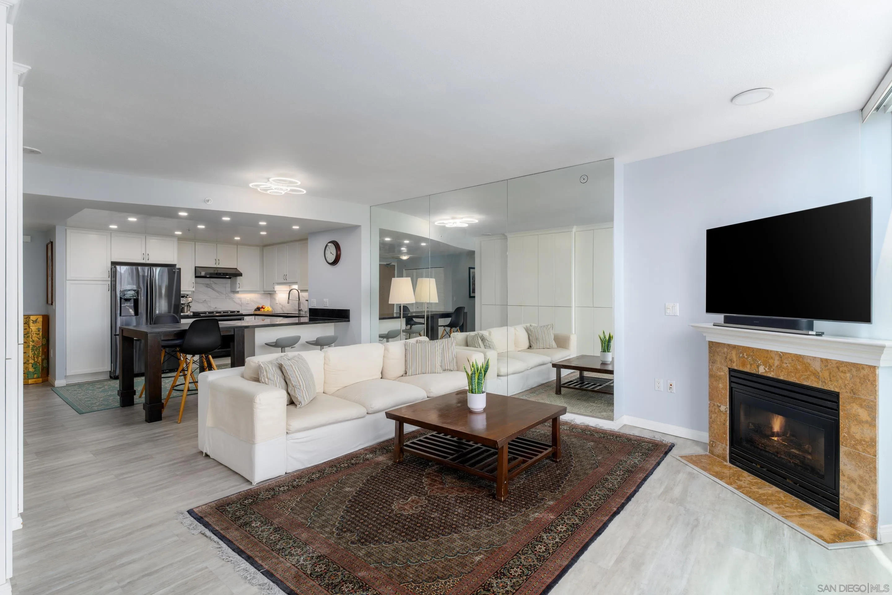 555 Front Street, Unit 303 San Diego, CA 92101 - Photo 5 of 35 a living room with furniture a flat screen tv and a fireplace