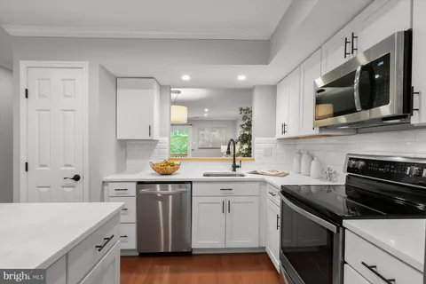 a kitchen with stainless steel appliances a sink stove and microwave