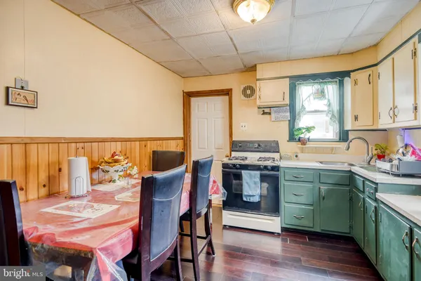a kitchen with a table chairs stove and cabinets