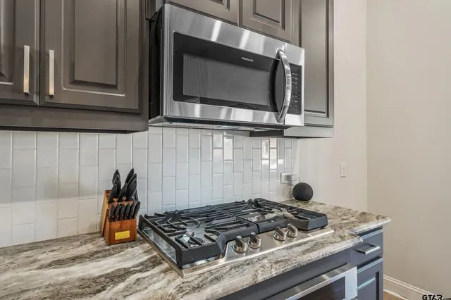 a kitchen with stainless steel appliances granite countertop a stove and a microwave