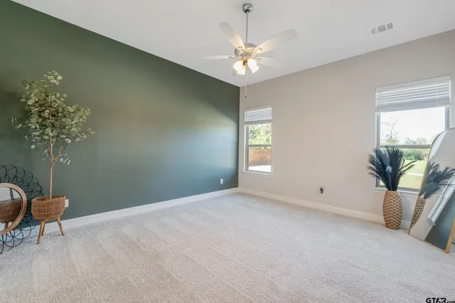 a view of a livingroom with a chandelier fan and a window