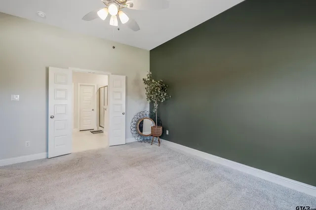 a view of a room with a chandelier fan and a window