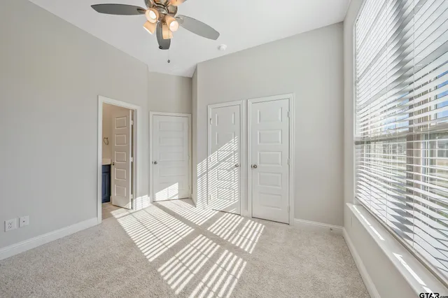 a spacious bedroom with a bed and a chandelier