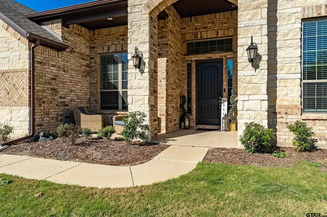 a view of a brick house with plants in front of main door