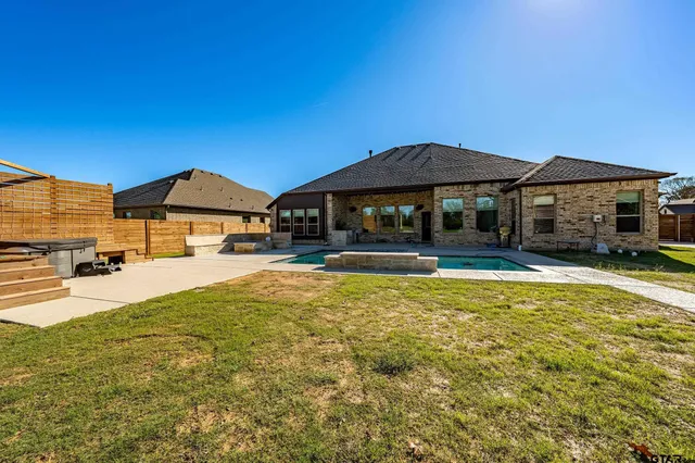 a swimming pool view with a seating space and a garden view