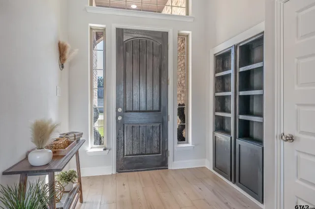 a view of a hallway with wooden floor and cabinet