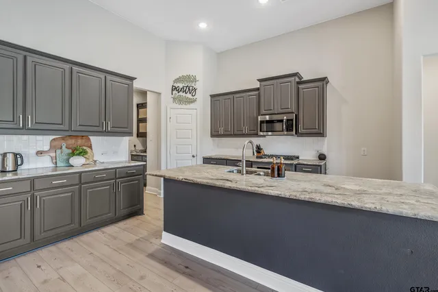 a kitchen with granite countertop a sink stainless steel appliances and cabinets
