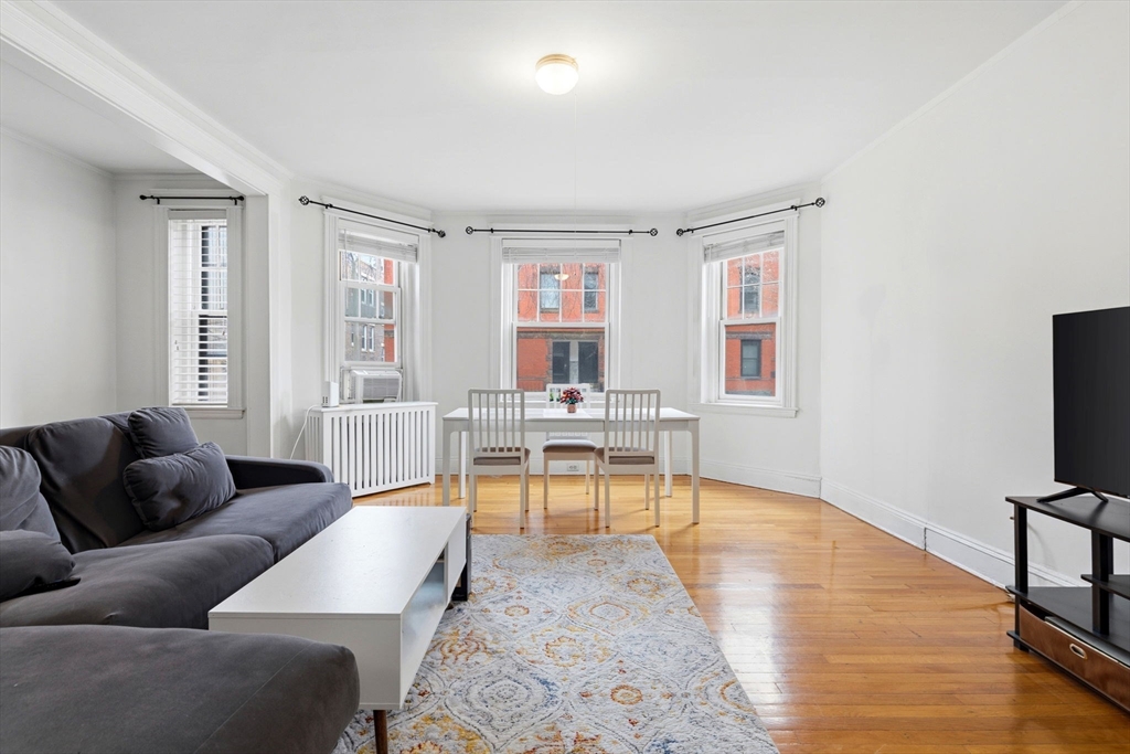 73 Parkman Street, Unit 1 Brookline, MA 02446 - Photo 2 of 10 a living room with furniture a flat screen tv and a large window