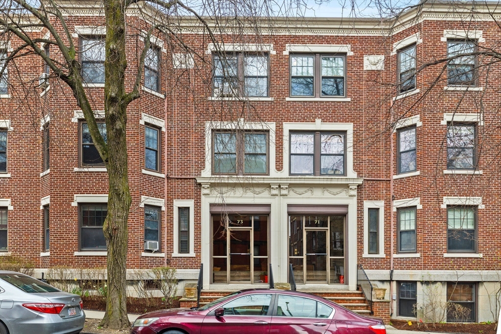 73 Parkman Street, Unit 1 Brookline, MA 02446 - Photo 10 of 10 a front view of a building with a lot of windows and plants