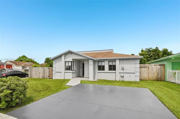 a front view of a house with a garden and yard