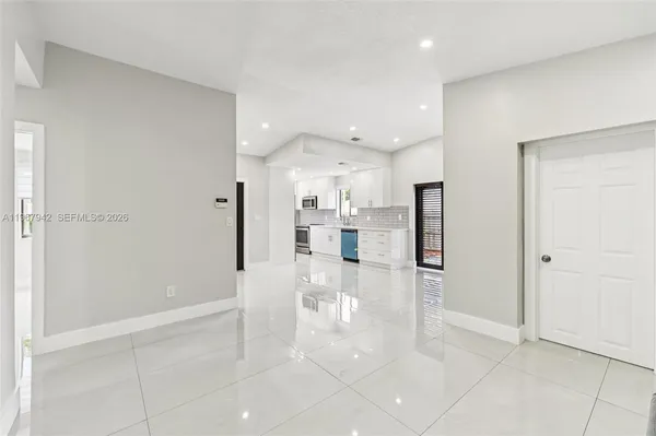 a view of a kitchen with refrigerator and a living room