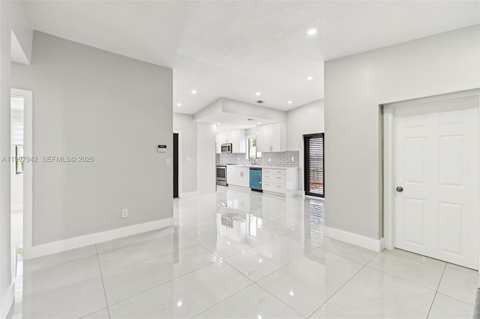 12237 Southwest 193rd Street Miami, FL 33177 - Photo 11 of 41 a view of a kitchen with refrigerator and a living room