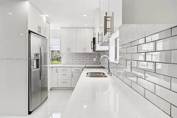a kitchen with a refrigerator a sink and wooden cabinets