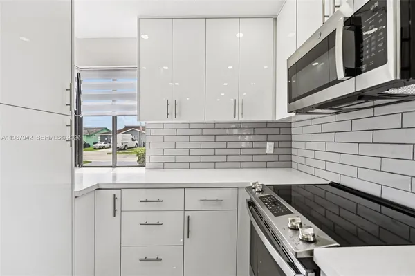 a kitchen with granite countertop white cabinets and white appliances