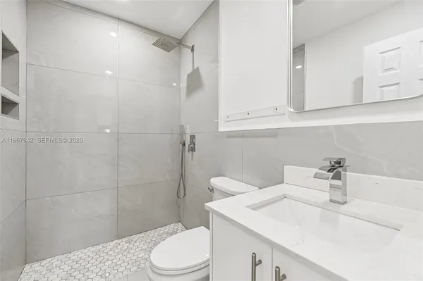 a bathroom with a sink a toilet and shower