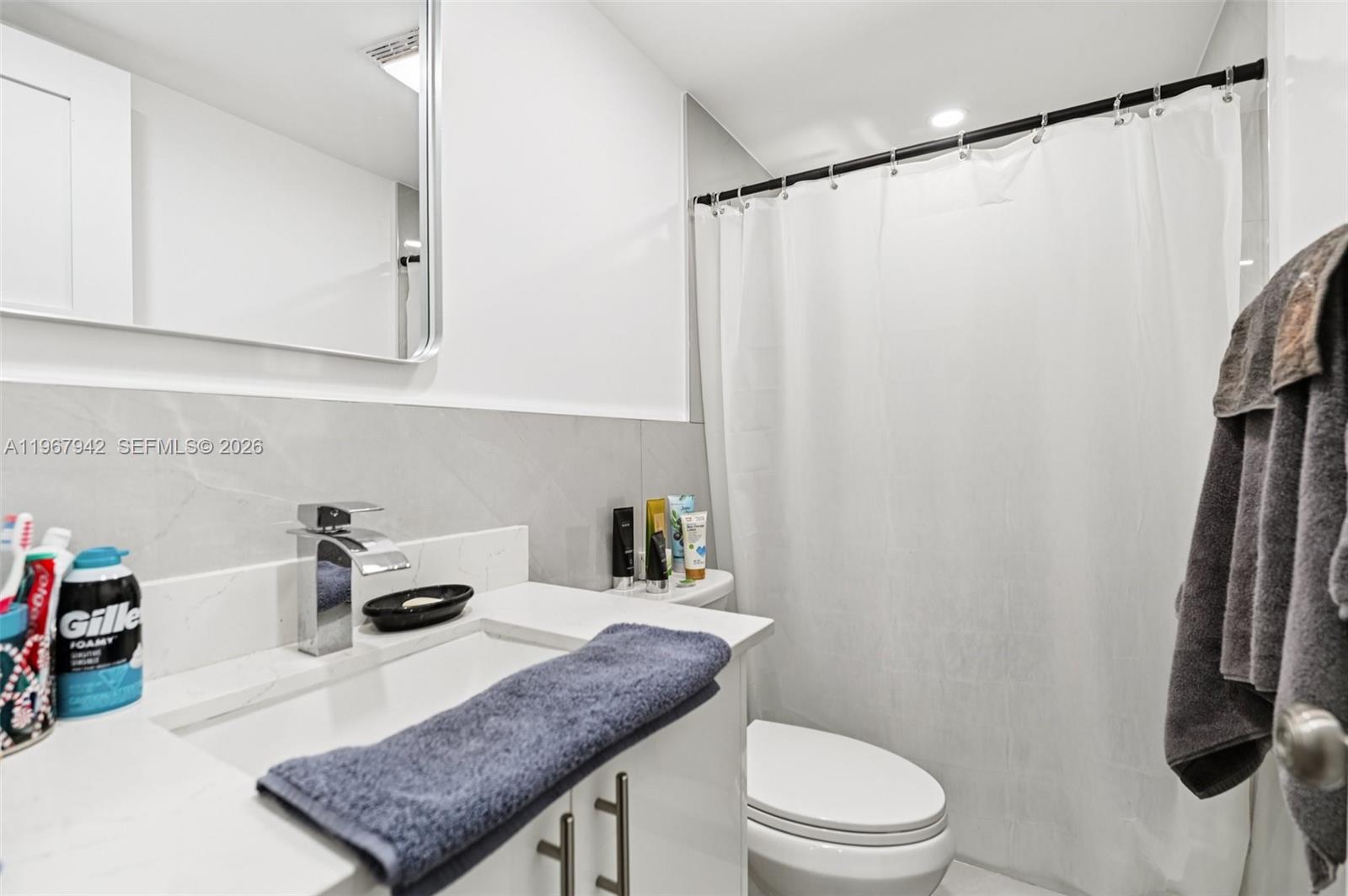 12237 Southwest 193rd Street Miami, FL 33177 - Photo 34 of 41 a bathroom with a sink a toilet and shower curtain