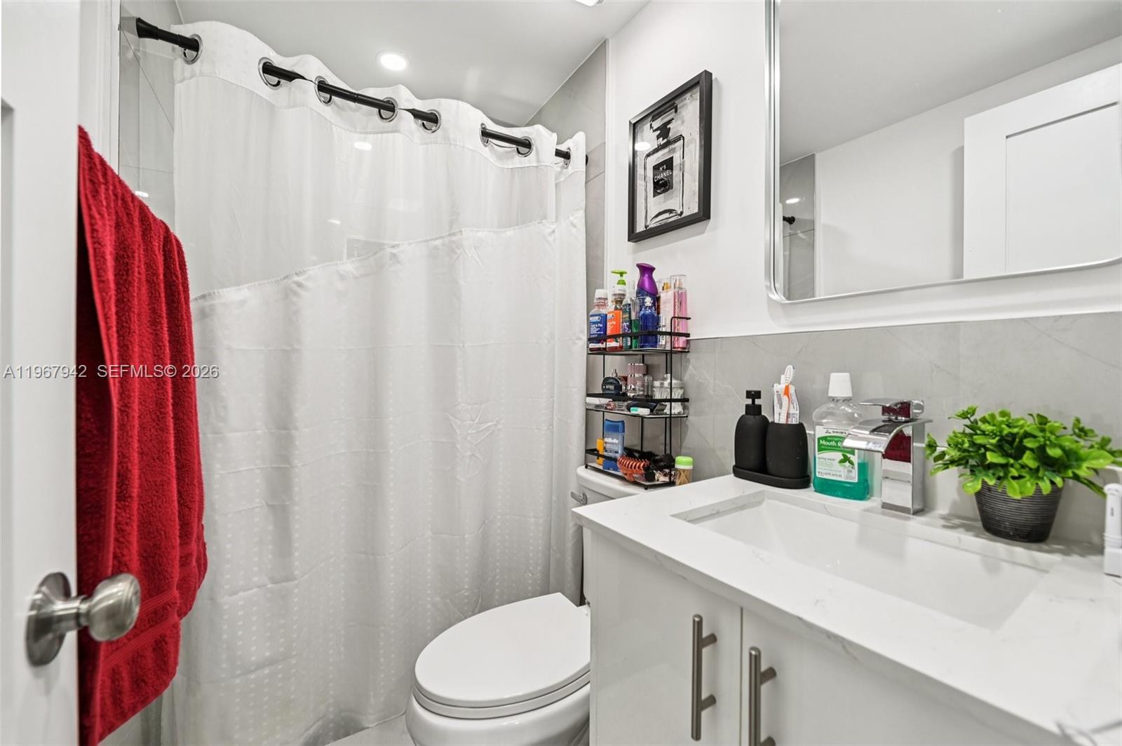 12237 Southwest 193rd Street Miami, FL 33177 - Photo 39 of 41 a bathroom with a sink a toilet and shower curtain
