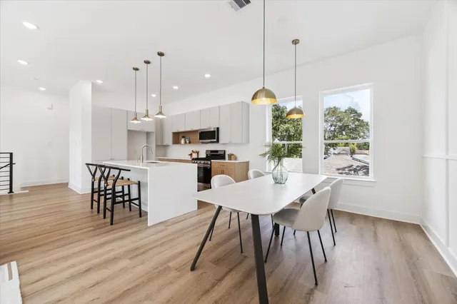 a view of a dining room and livingroom with furniture wooden floor a chandelier