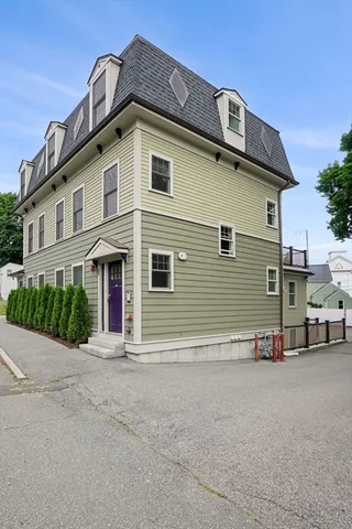 a front view of a house with plants and trees