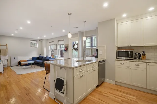 a kitchen with a sink white cabinets and counter space