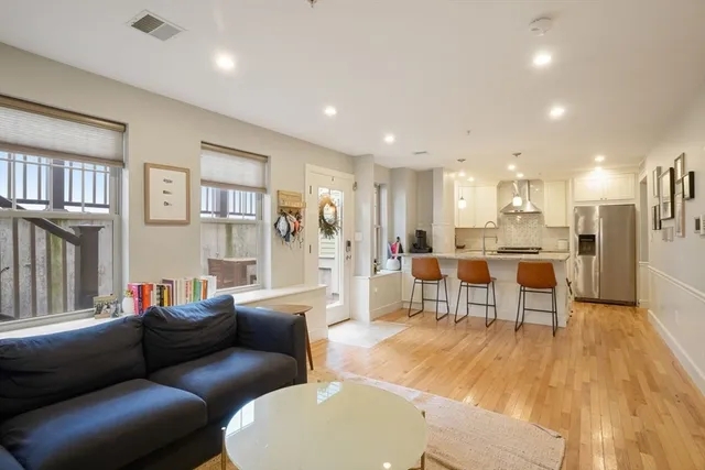 a living room with furniture and a view of kitchen