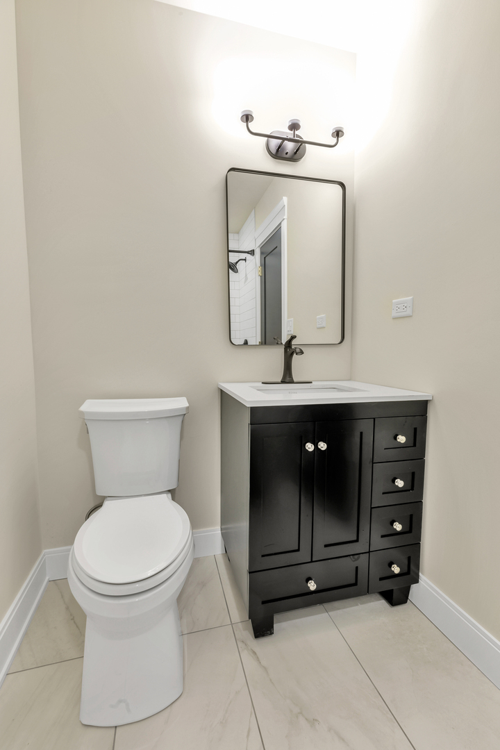 317 Canal Street, Unit B Lemont, IL 60439 - Photo 13 of 15 a bathroom with a toilet a sink and mirror