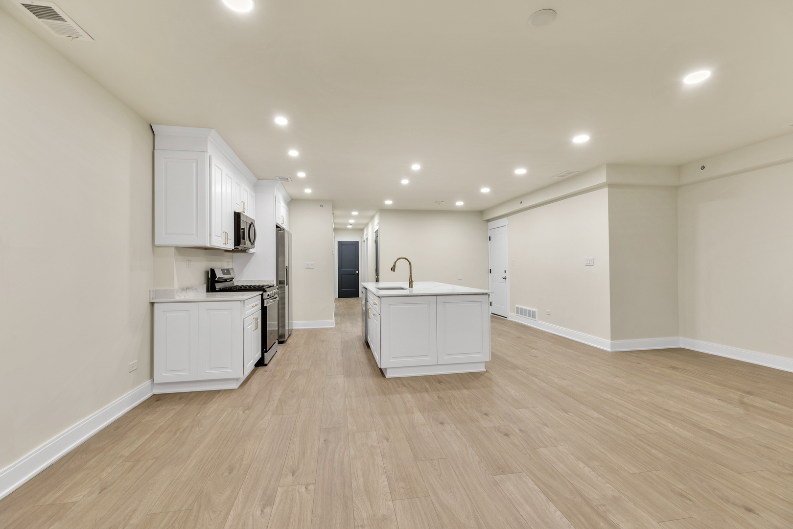 317 Canal Street, Unit B Lemont, IL 60439 - Photo 4 of 15 a large white kitchen with kitchen island a sink a center island stainless steel appliances and a counter top