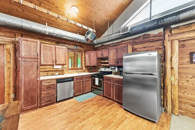 a kitchen with stainless steel appliances granite countertop a refrigerator a stove a sink and dishwasher