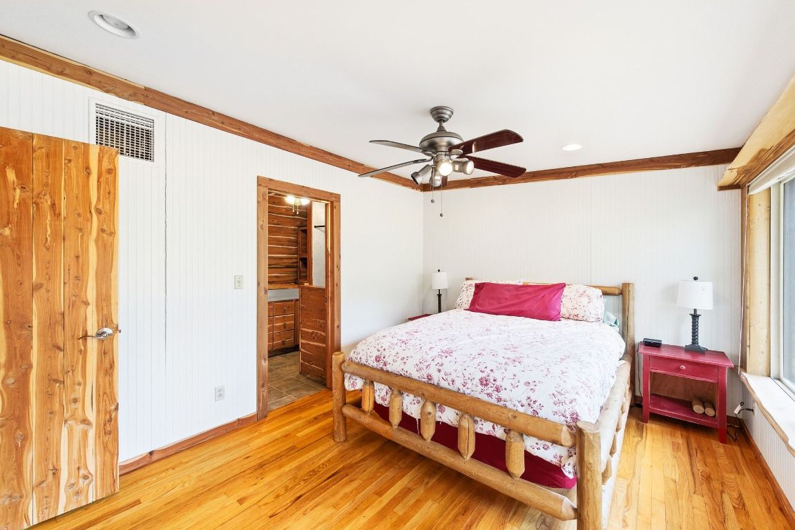 235 Antioch Road Paige, TX 78659 - Photo 16 of 40 a bedroom with a bed and wooden floor