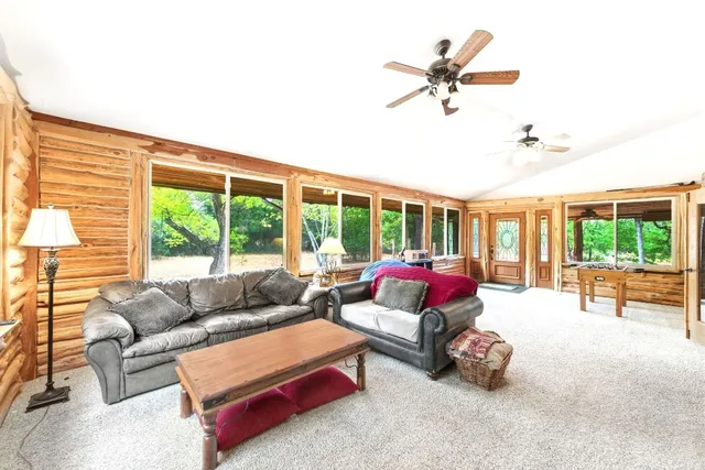 a living room with furniture and a large window with garden view