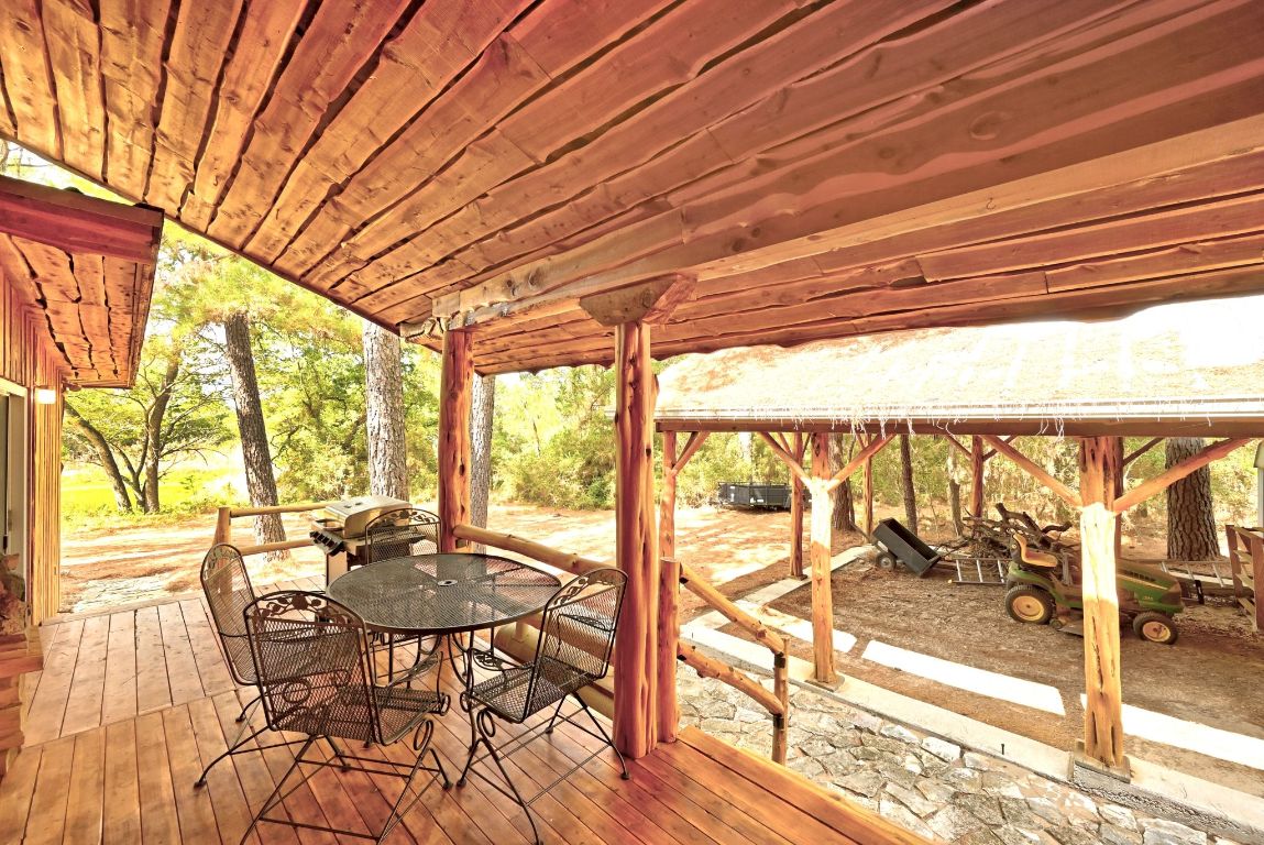 235 Antioch Road Paige, TX 78659 - Photo 26 of 40 a view of a patio with table and chairs and wooden floor