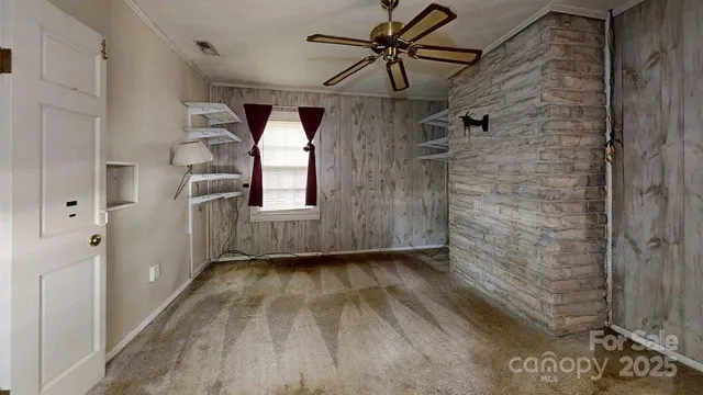 a view of a hallway with wooden floor and a ceiling fan