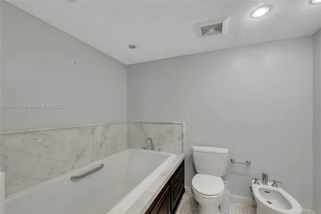 a white toilet sitting next to a bath tub