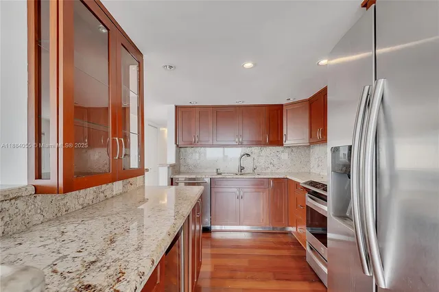 a kitchen with stainless steel appliances granite countertop a refrigerator and a sink