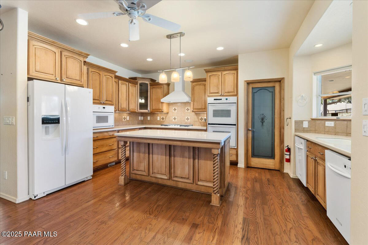 5540 Deer Spring Place Prescott, AZ 86305 - Photo 13 of 46 a kitchen with stainless steel appliances granite countertop a refrigerator a sink dishwasher a stove and white countertops with wooden floor
