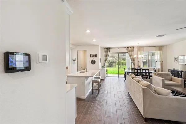 a living room with furniture floor to ceiling window and wooden floor