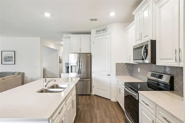 a kitchen with white cabinets and stainless steel appliances