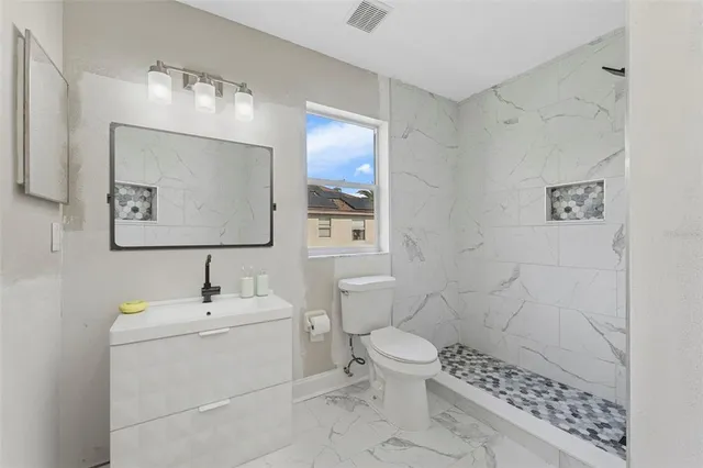 a bathroom with a toilet sink and mirror