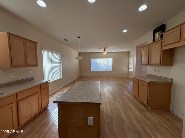 a kitchen with stainless steel appliances wooden floors wooden cabinets and entryway