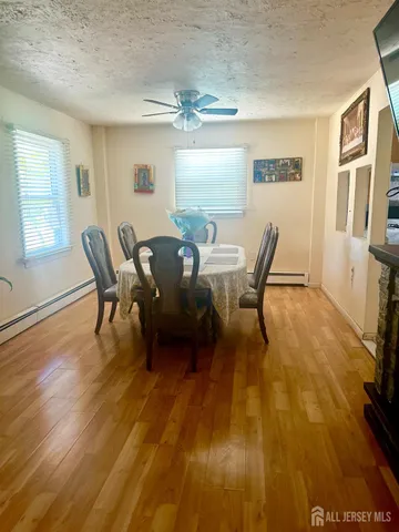 a view of a dining room with furniture a chandelier and wooden floor