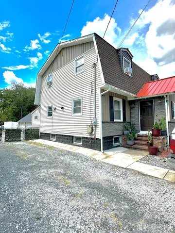 a view of a house with backyard and sitting area