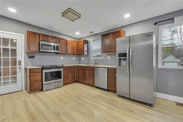 a kitchen with stainless steel appliances granite countertop a refrigerator stove and sink
