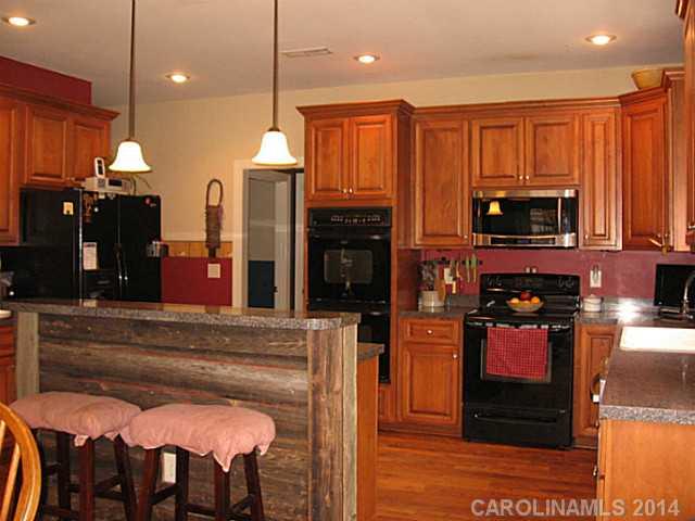 6028 Springhill Road, Unit 25 Stanfield, NC 28163 - Photo 5 of 15 a kitchen with stainless steel appliances granite countertop a refrigerator and a stove top oven